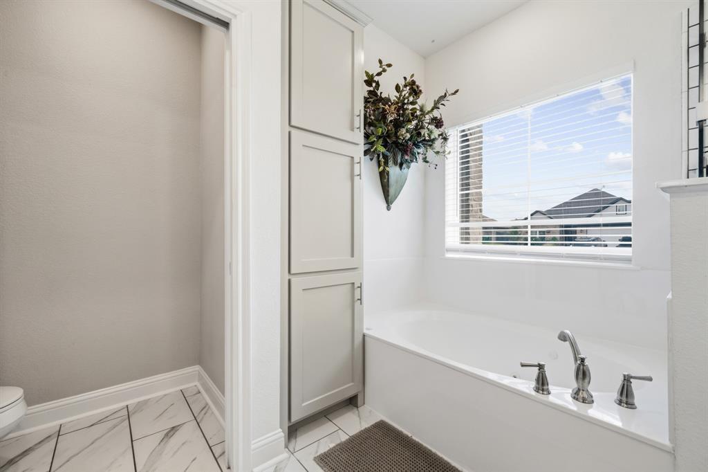 Built-in soaking tub featuring brushed nickel hardware