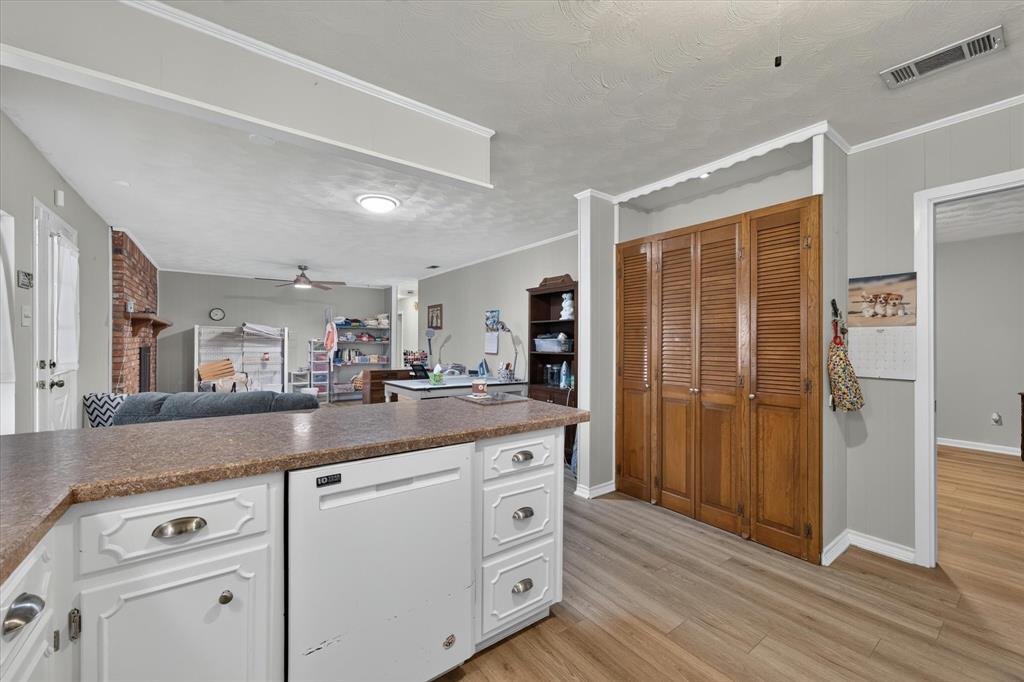 Kitchen featuring white cabinetry with brushed nickel hardware, a built-in dishwasher, and a laminate countertop
