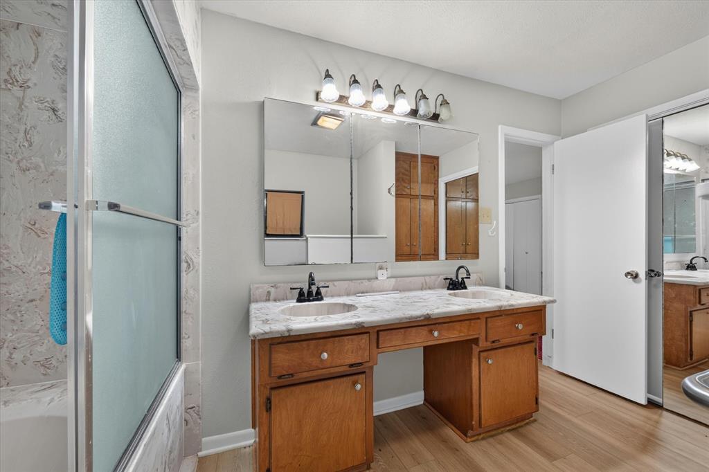 Double vanity with integrated sinks, granite-look countertop, and wood-finish cabinetry