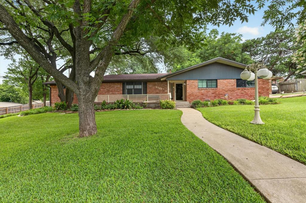 Brick-clad exterior with a prominent front walkway and lush green lawn Brick-clad exterior with a prominent front walkway and lush green lawn