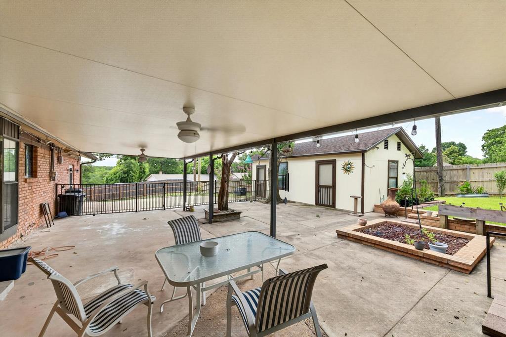 Expansive covered patio featuring two ceiling fans and concrete flooring