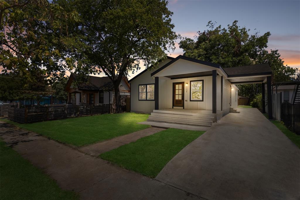 Contemporary single-story residence with a covered entryway, attached carport, concrete driveway, and manicured front lawn