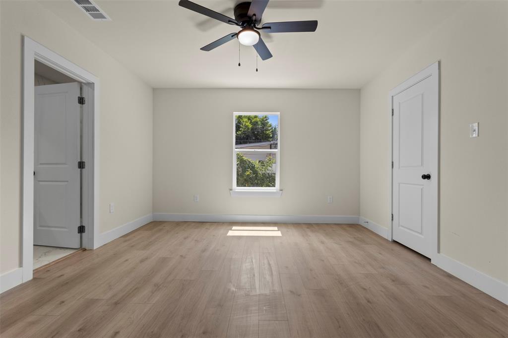 Wood-finish flooring, crisp white trim, and a ceiling fan with integrated lighting