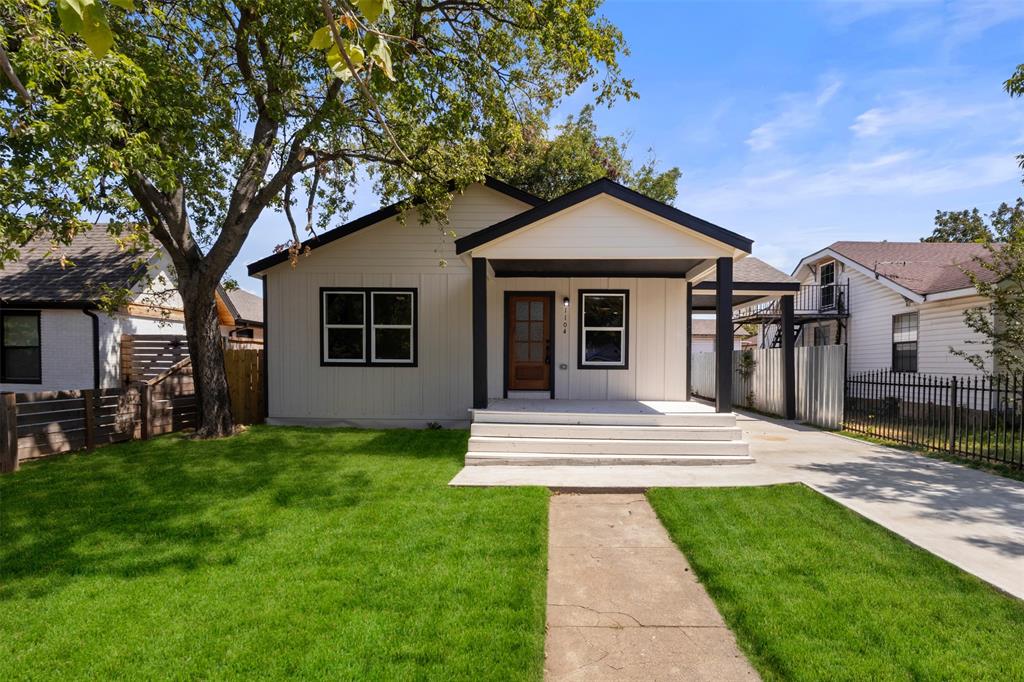 Contemporary exterior with white siding, black trim, and a wood-finish front door Contemporary exterior with white siding, black trim, and a wood-finish front door