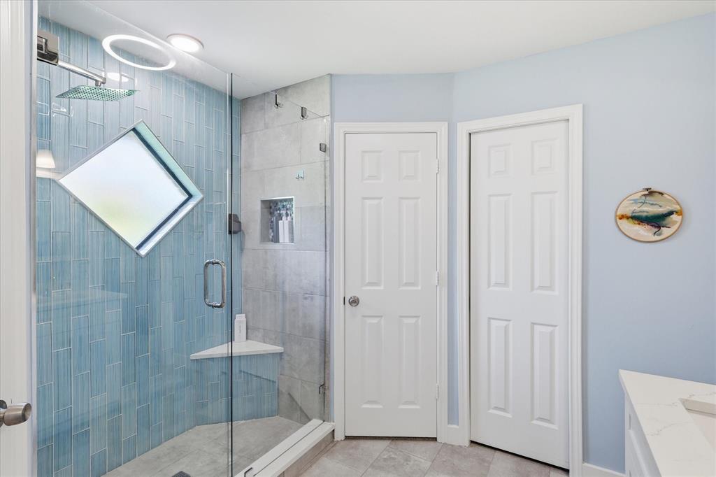 Shower features a soap niche and an angled shelf.