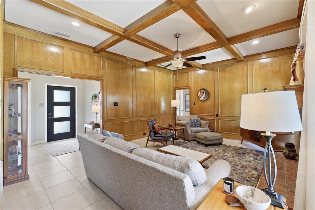 Picture frame paneling and decorative beams make this a warm and cozy living space.