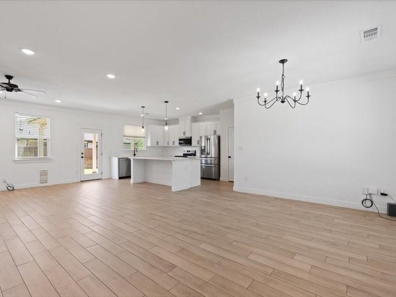 Open-concept living space featuring wood-look tile flooring and white walls