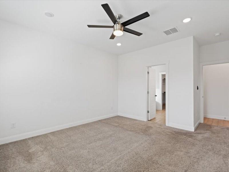 Room featuring neutral carpet flooring, white walls, and a contemporary ceiling fan with integrated lighting