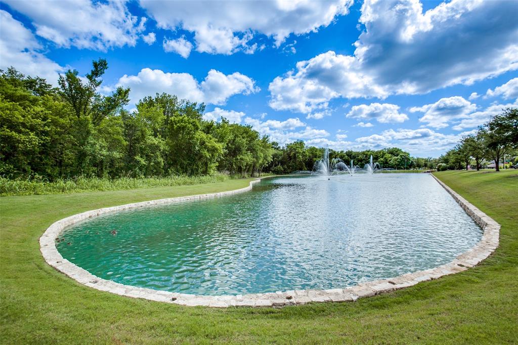Expansive water feature with multiple fountains and a stone-lined border