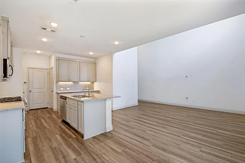 Kitchen island with built-in sink, stainless steel dishwasher, and bar seating