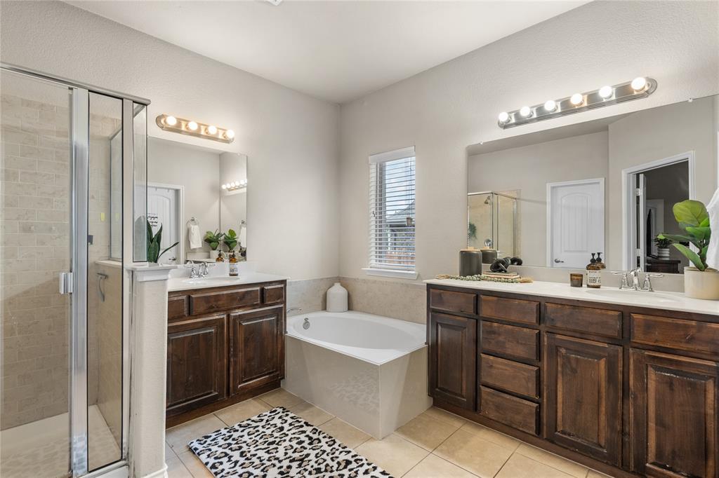 Ensuite primary bathroom features garden tub and separate shower.