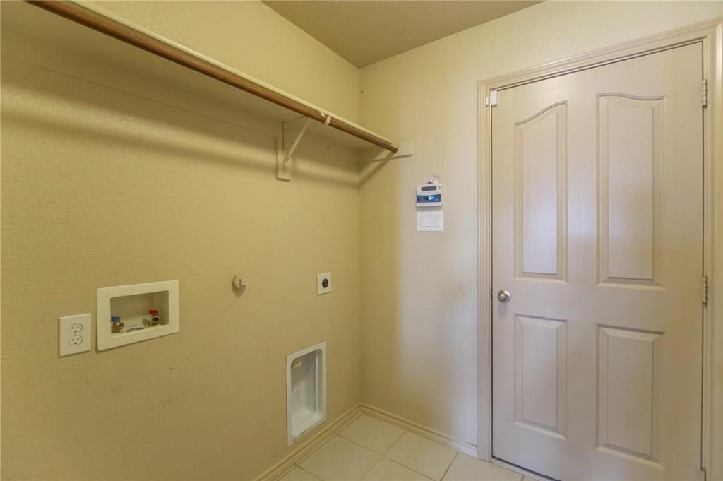 Utility area with tile flooring and a built-in hanging rod