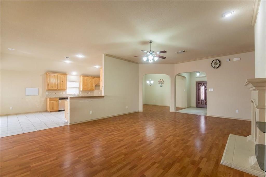 Spacious interior featuring wood-finish flooring, recessed lighting, and a prominent fireplace with a decorative mantel
