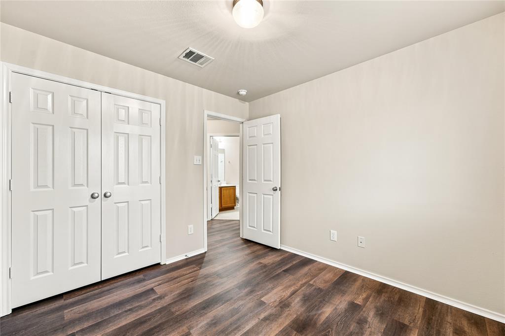 Interior room with wood-finish flooring, light-toned walls, and a ceiling-mounted light fixture