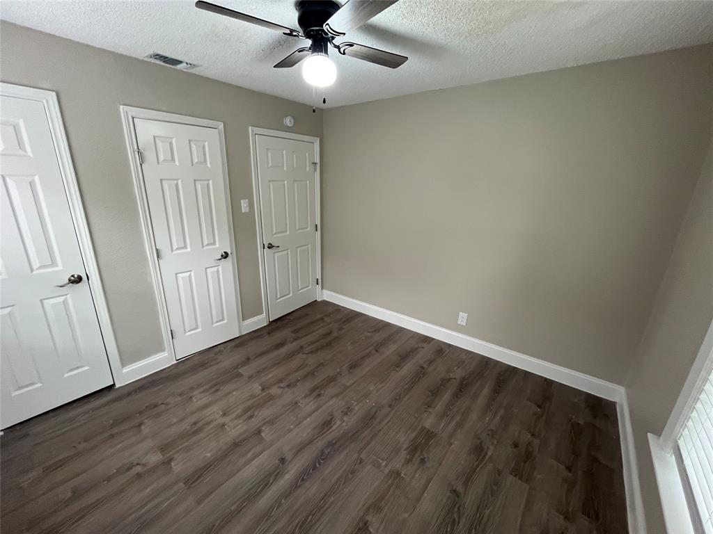 Interior room featuring wood-finish flooring, light neutral wall paint, and white trim