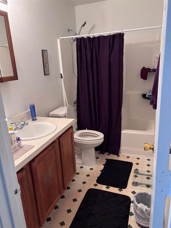 Bathroom featuring a vanity with wood-finish cabinetry, a white countertop, and a white porcelain sink