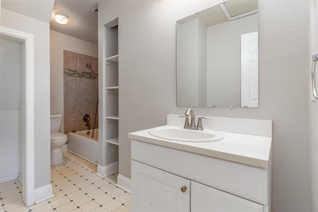 Bathroom featuring a single-sink vanity with white countertop, chrome faucet, and mirrored medicine cabinet
