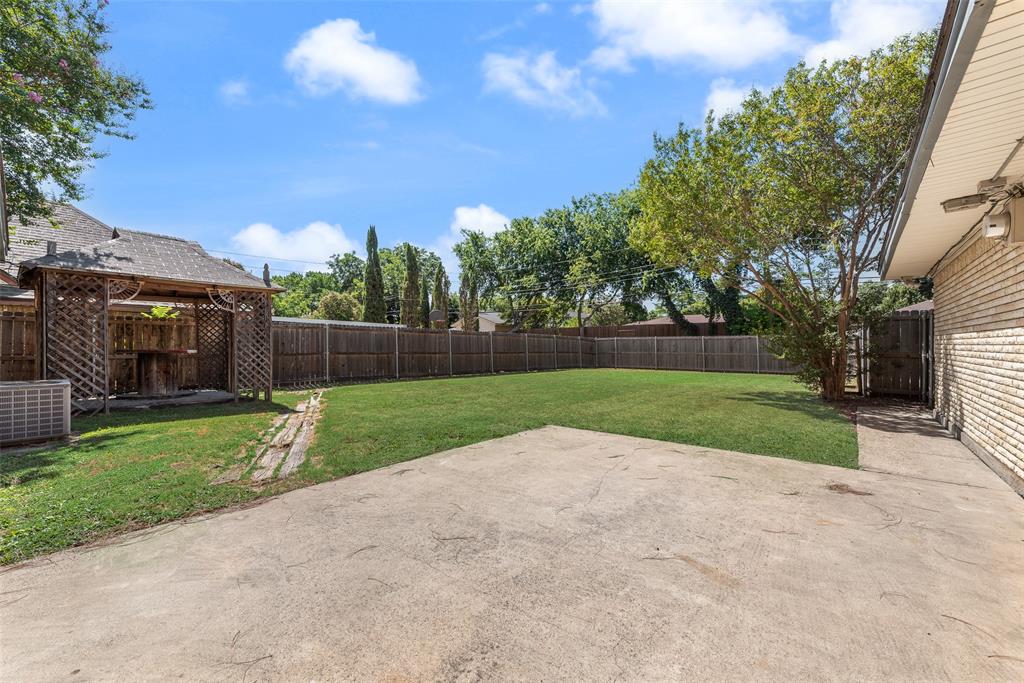 Large patio overlooking wood fenced backyard