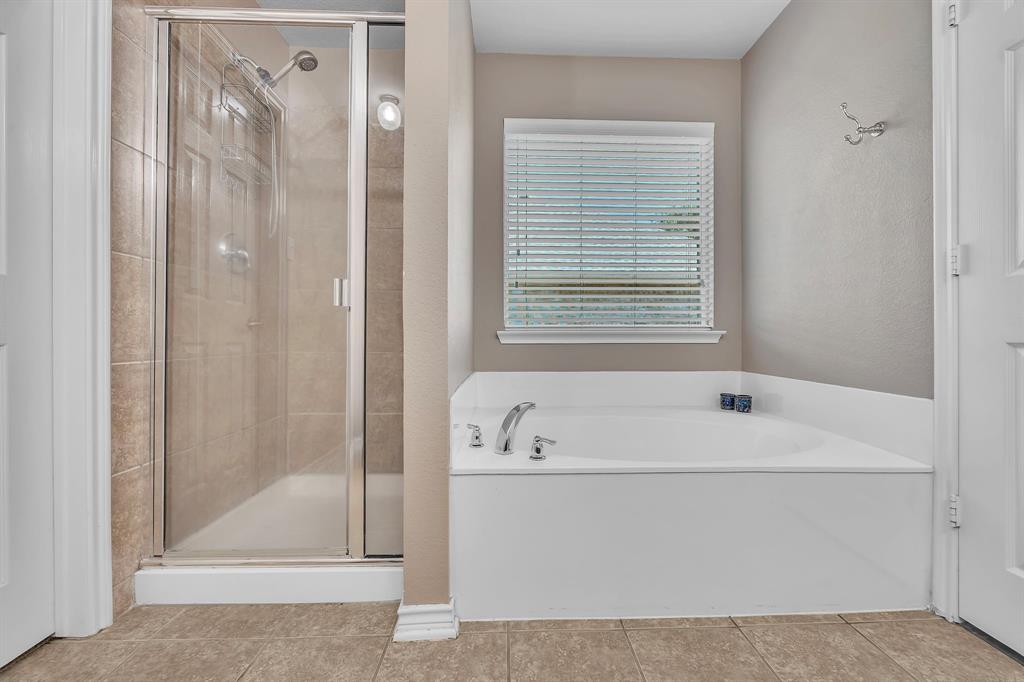 Walk-in shower with clear glass enclosure and tile surround