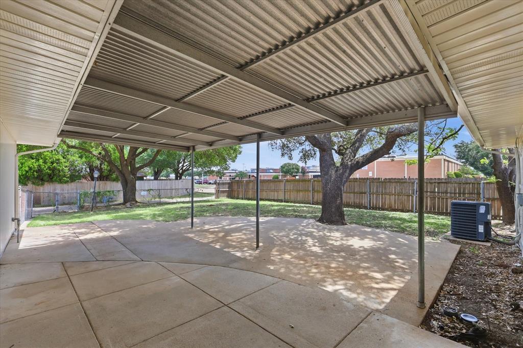 Expansive concrete patio with a full-length metal awning