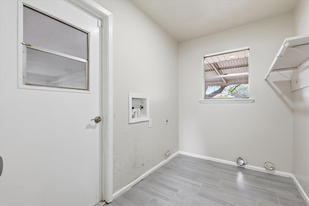 Utility room with wood-finish tile flooring, a window offering natural light, and built-in shelving