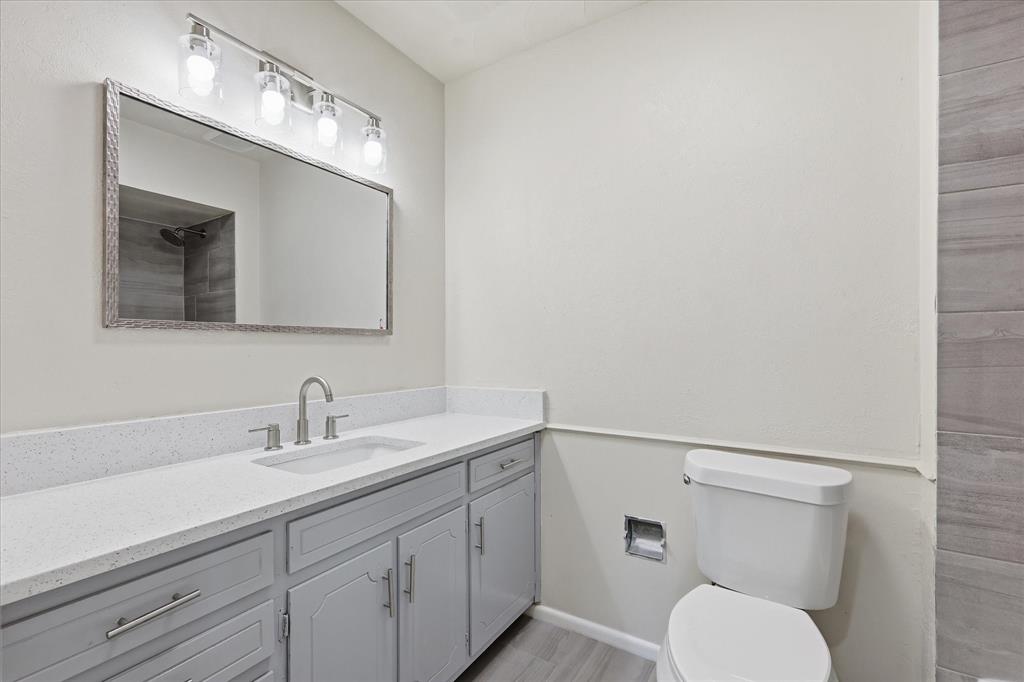 Bathroom vanity featuring a light quartz countertop, undermount sink, and brushed nickel fixtures