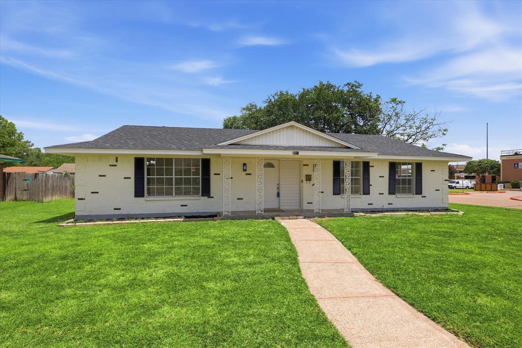 Single-story residence featuring a white brick exterior and a dark shingle roof