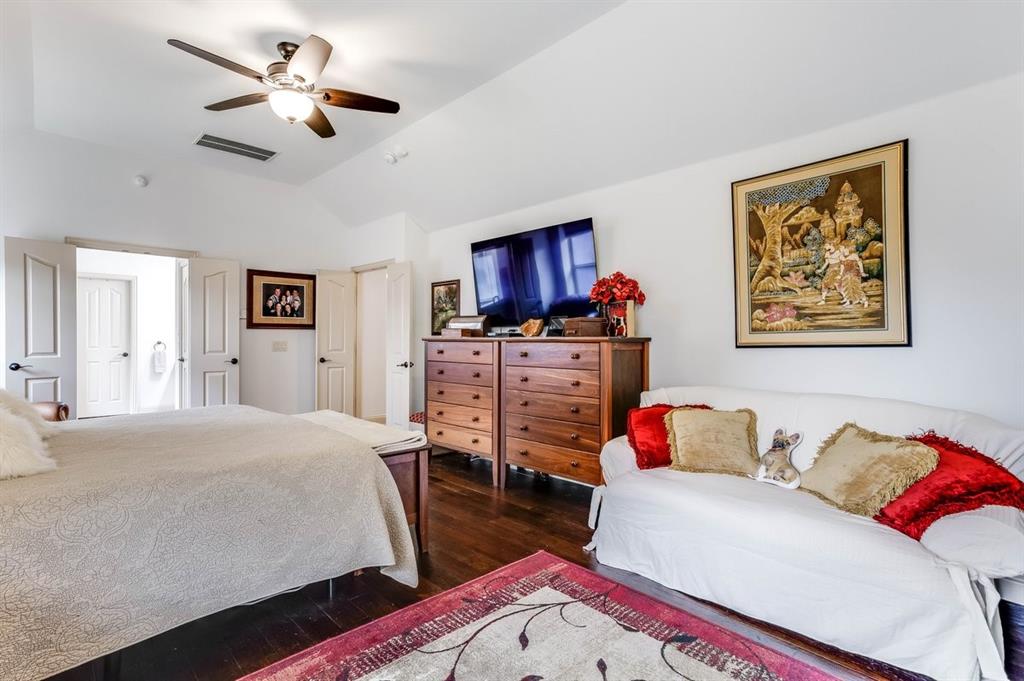 Spacious room featuring vaulted ceilings, dark wood-finish flooring, and white paneled doors