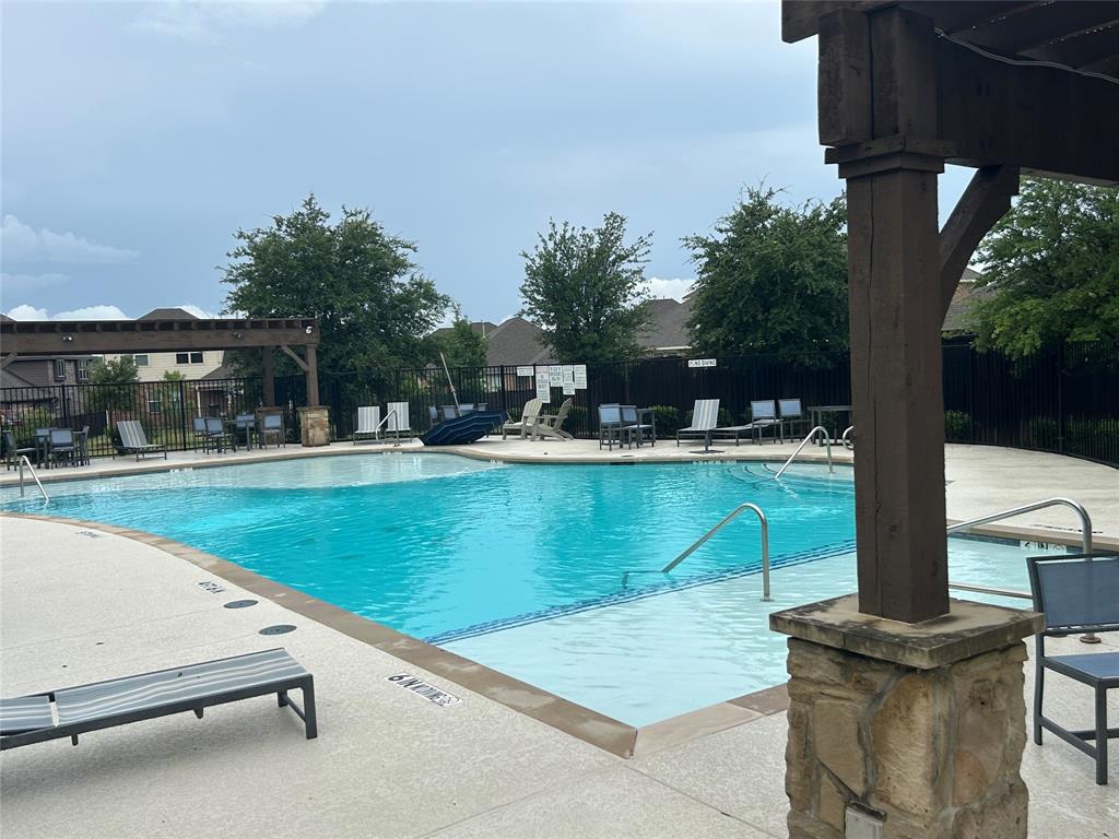 Community swimming pool featuring a curved design with integrated steps and perimeter handrails