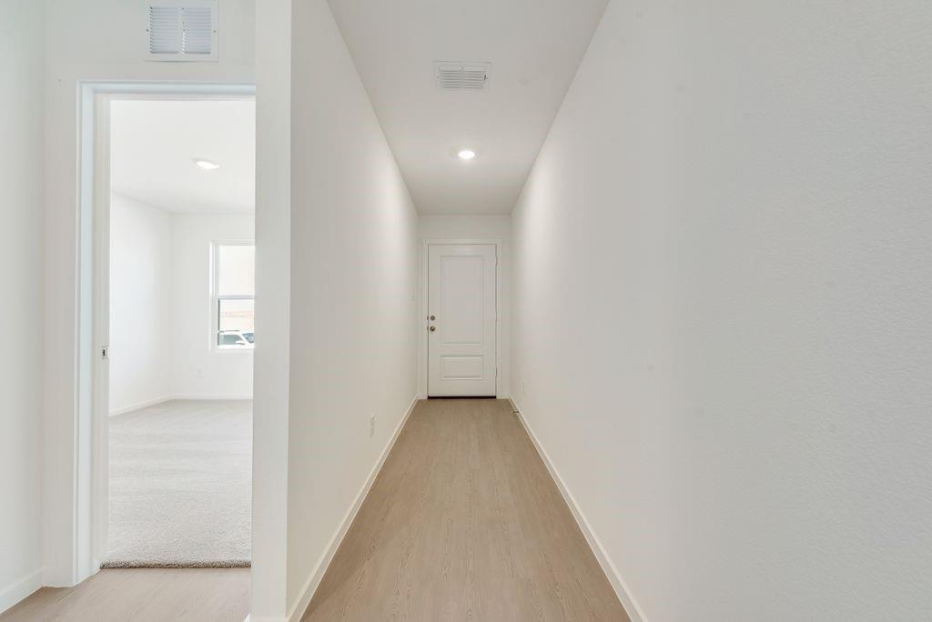 Hallway featuring light wood finished floors and baseboards Hallway featuring light wood finished floors and baseboards