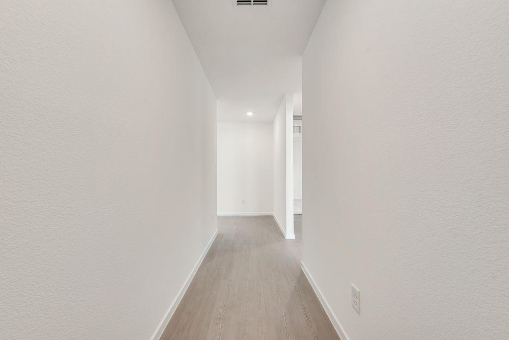 Corridor with wood finished floors and recessed lighting Corridor with wood finished floors and recessed lighting