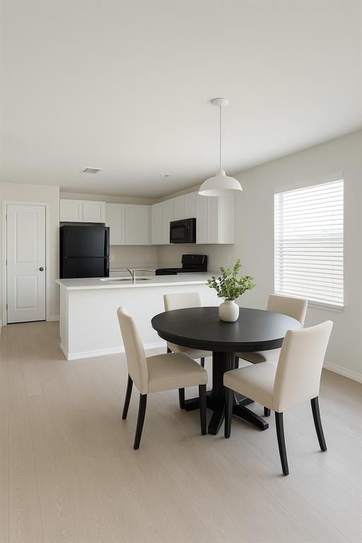 Dining space with light wood-style floors and baseboards