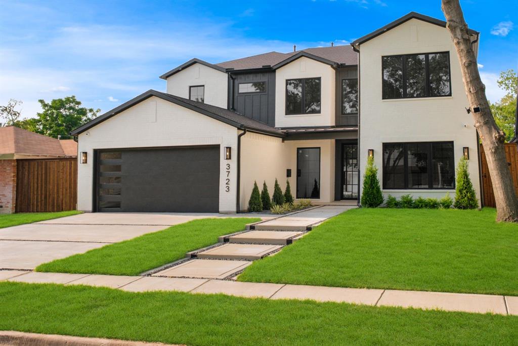 Contemporary two-story residence featuring a white facade with black trim accents and a black garage door with frosted glass panels