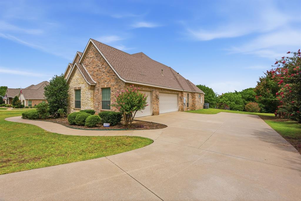 Brick and stone exterior with architectural gables, a two-car garage, and a concrete driveway