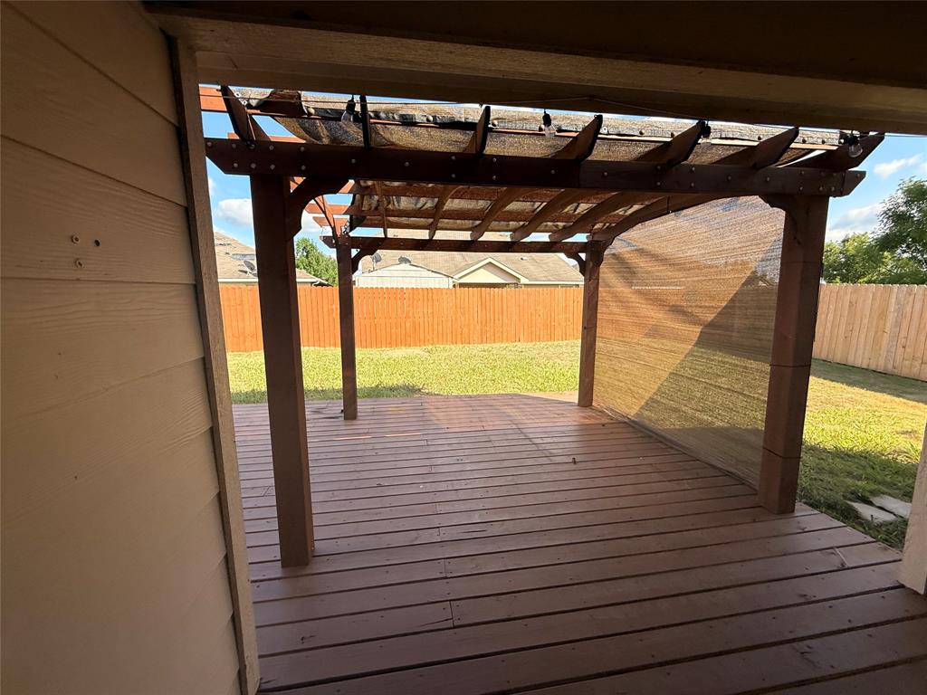 Wood-finish deck with a pergola featuring a mesh canopy and partial mesh side panels