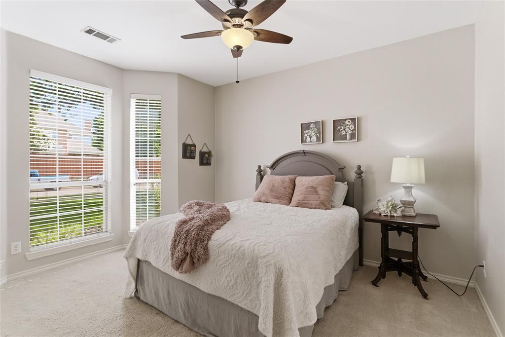 Carpeted room featuring a ceiling fan with integrated lighting, multiple windows with blinds, and light-toned walls