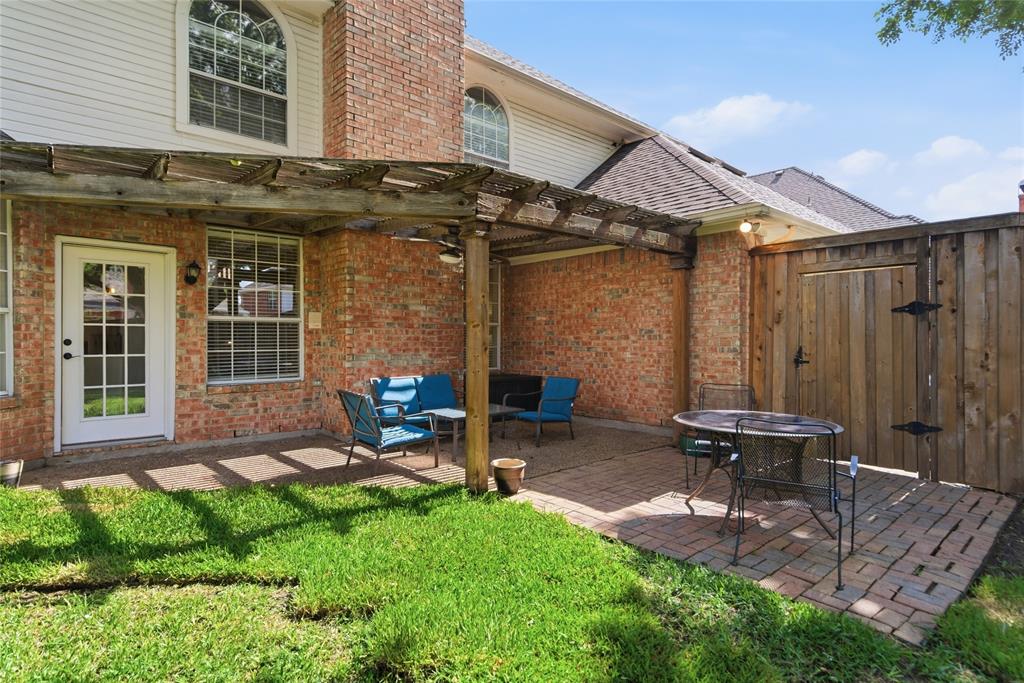 Brick exterior featuring an attached pergola over a paved patio