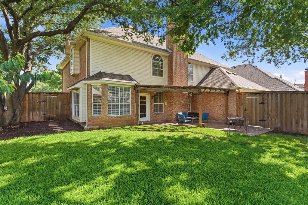 Expansive backyard featuring a manicured lawn and mature trees