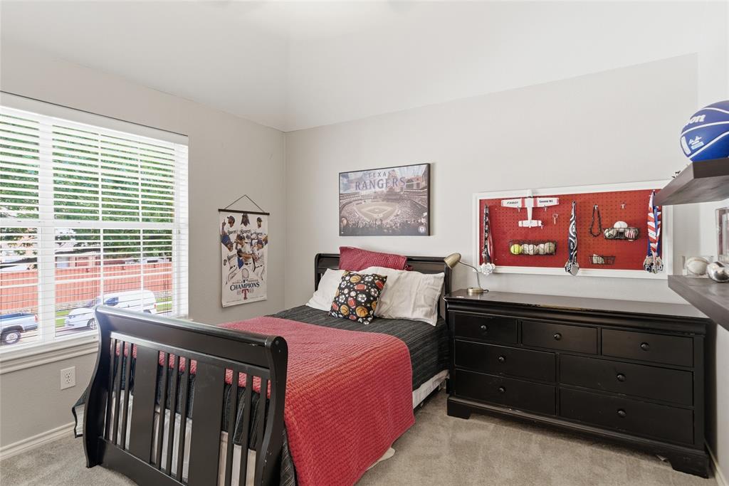 Carpeted room featuring a large window with blinds, light gray walls, and a vaulted ceiling