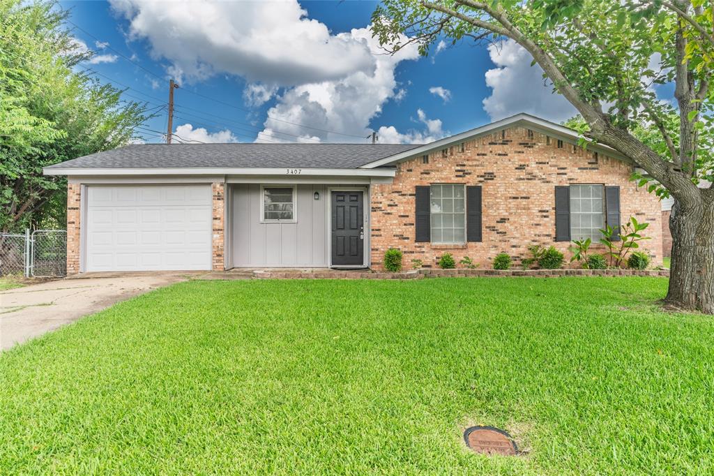 Brick and siding exterior featuring a single-car garage, mature front yard tree, and an established lawn