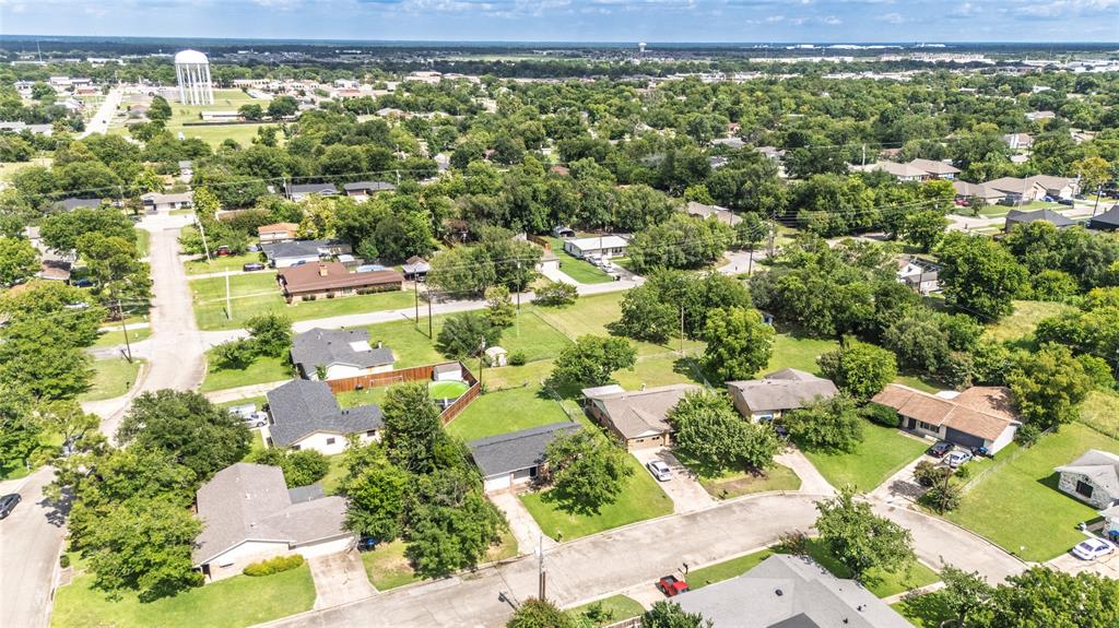 Expansive residential area featuring numerous mature trees and a water tower in the distance