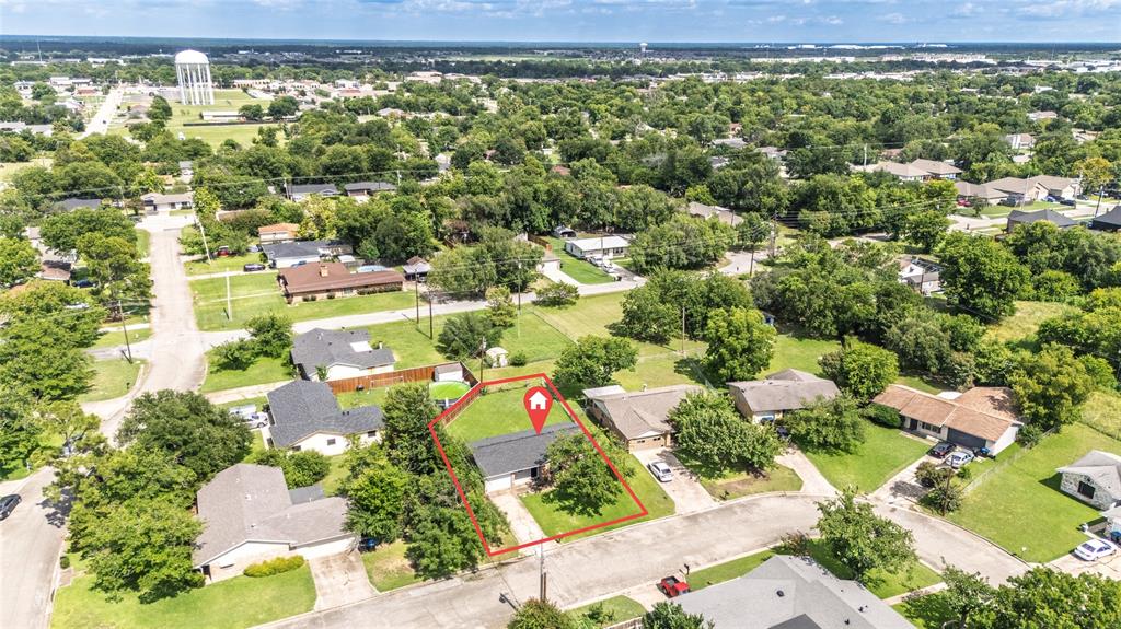 Aerial perspective highlighting a single-story residence with a dark shingle roof and a concrete driveway
