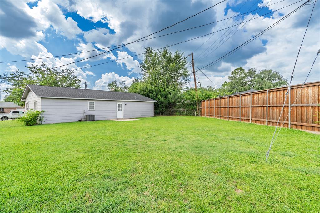 Expansive green lawn with a solid wood privacy fence