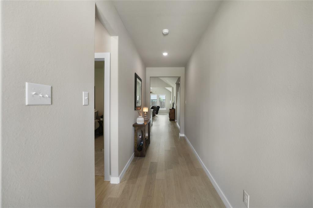 Hallway featuring light-toned wood-finish flooring, recessed lighting, and neutral wall paint