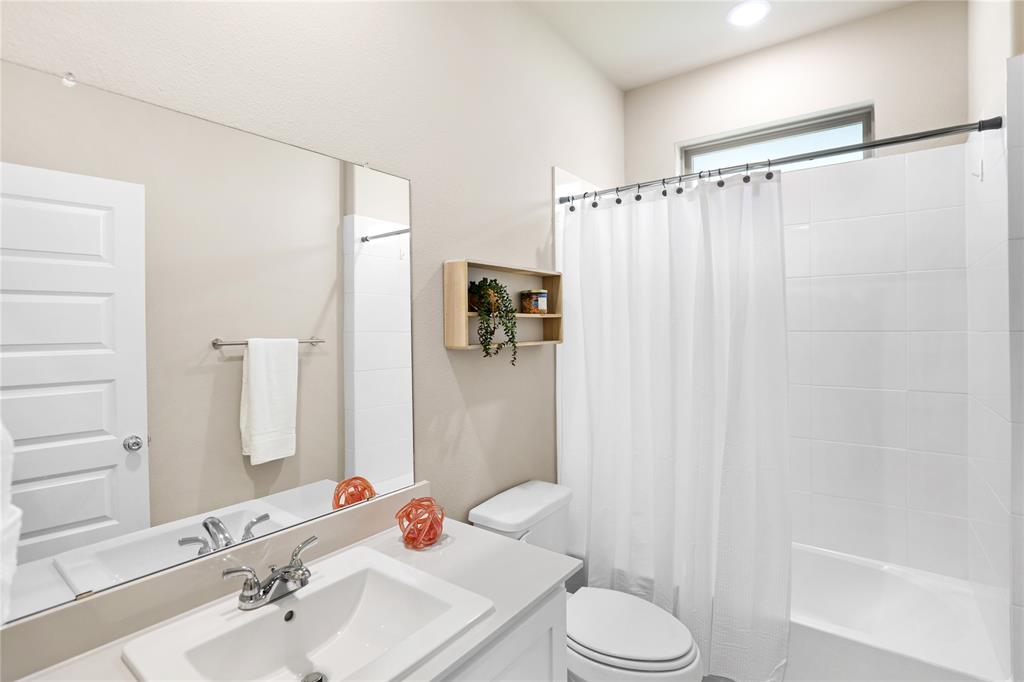 Bathroom featuring a single vanity with an integrated sink and chrome fixtures