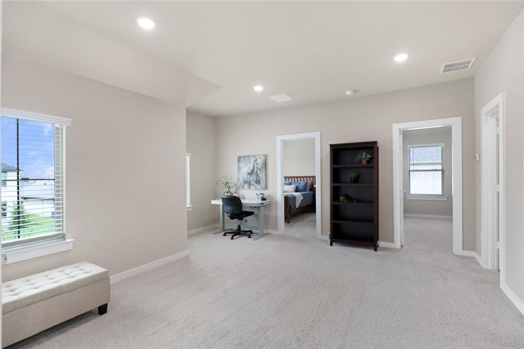 Spacious open concept room with light-colored carpeting, multiple doorways, recessed lighting, and a window with horizontal blinds