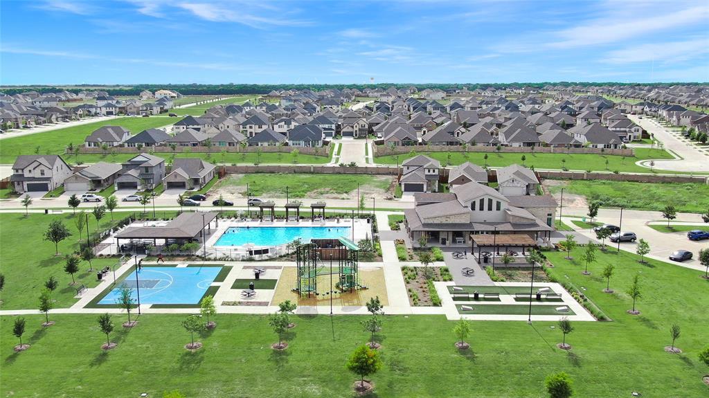 Community clubhouse and amenity center featuring a swimming pool, basketball court, and green spaces
