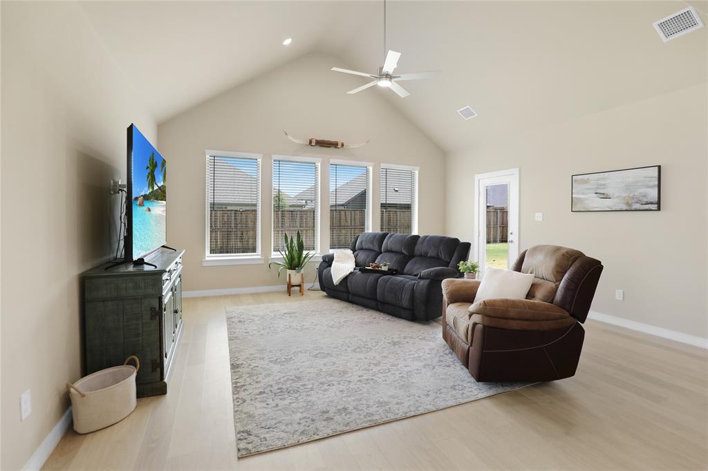 Vaulted ceiling great room featuring wood-finish flooring, recessed lighting, and a ceiling fan