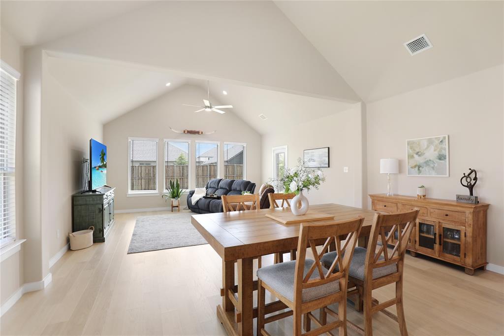 Vaulted ceilings highlight the open-concept living space, featuring light wood-finish flooring and recessed lighting