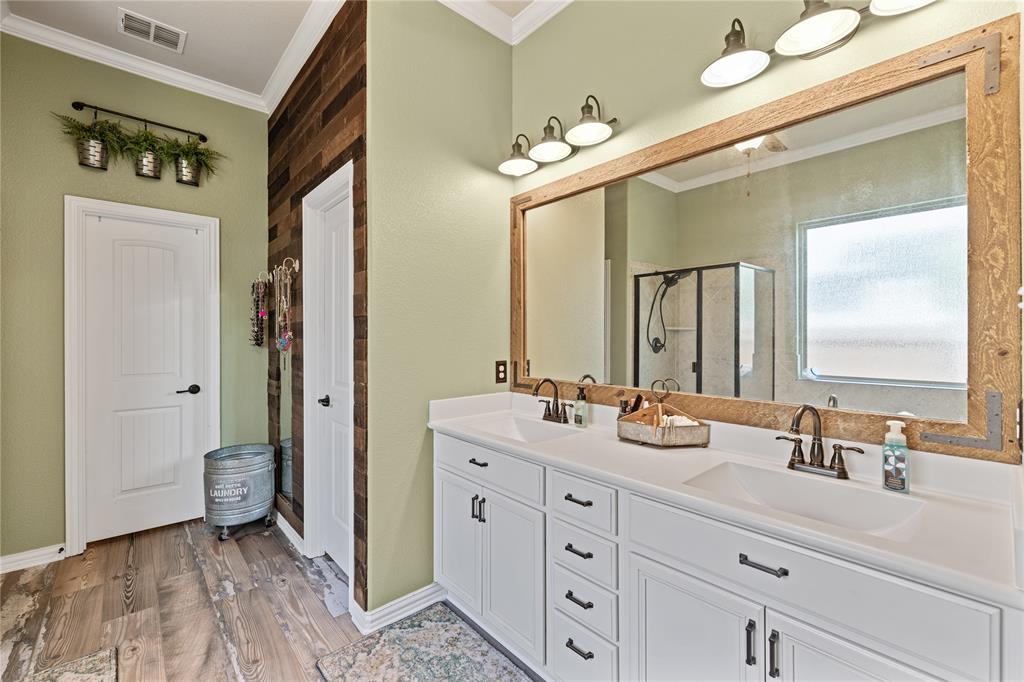 Bathroom featuring ornamental molding, walk in shower, hardwood / wood-style flooring, and dual vanity